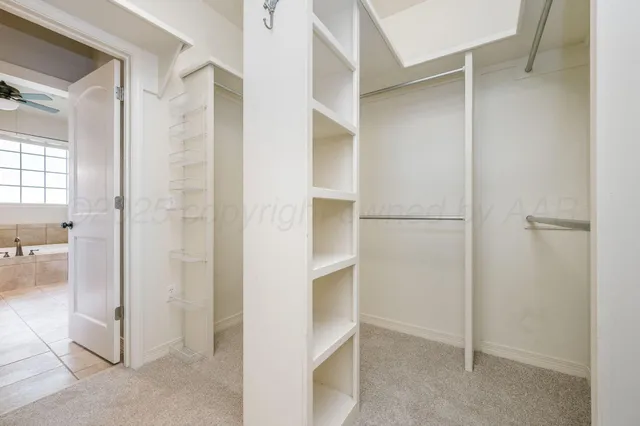 an empty room with chandelier fan