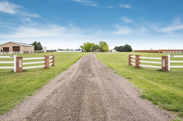 a view of a lake with a yard and large trees