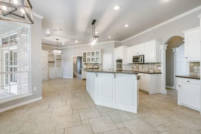 a view of kitchen with granite countertop cabinets and refrigerator