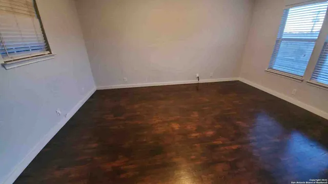 a view of a room with wooden floor and windows