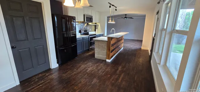 a kitchen with a refrigerator and wooden floor