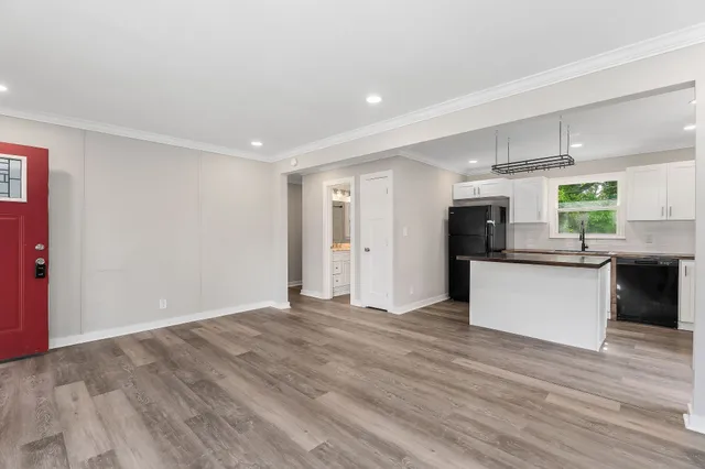 a view of kitchen with stainless steel appliances kitchen island wooden floors and center island