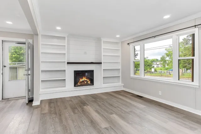 an empty room with windows and a fireplace