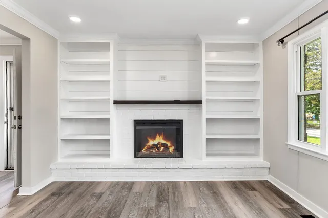 a view of an empty room with a fireplace and a window