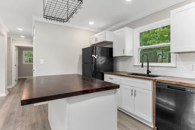 a kitchen with stainless steel appliances granite countertop a sink a stove and a refrigerator