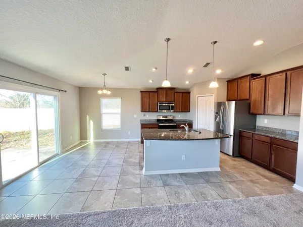 a large kitchen with a large counter top stainless steel appliances and cabinets