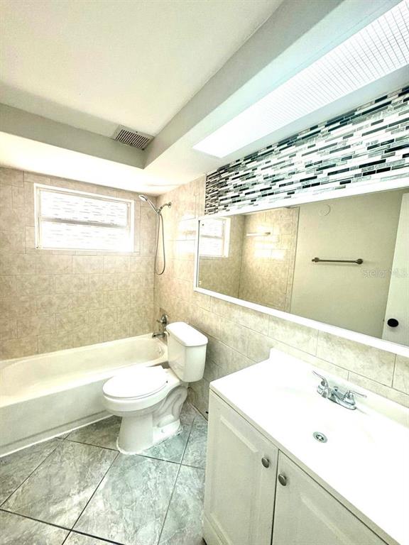 1019 Pert Lane Holiday, FL 34691 - Photo 8 of 12 a bathroom with a sink a toilet and bathtub