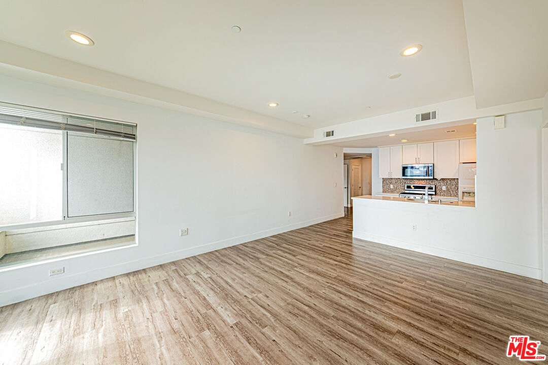 1101 South Harvard Boulevard, Unit 303 Los Angeles, CA 90006 - Photo 6 of 44 a view of a kitchen with wooden floor and a sink