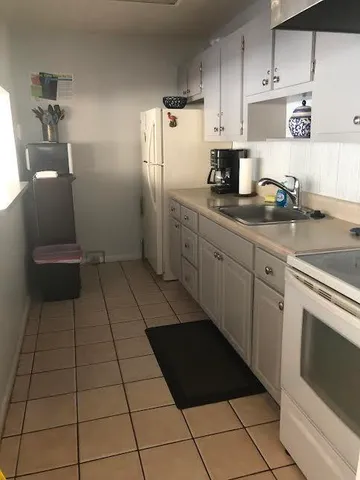 a kitchen with stainless steel appliances a sink a stove a refrigerator and cabinets