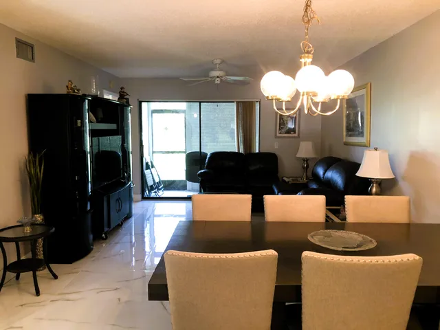a dining room with furniture and chandelier stainless steel appliances