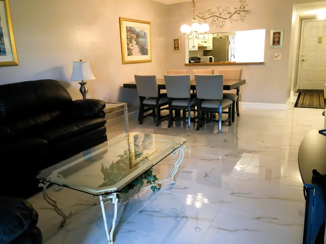 a living room with furniture a table and kitchen view