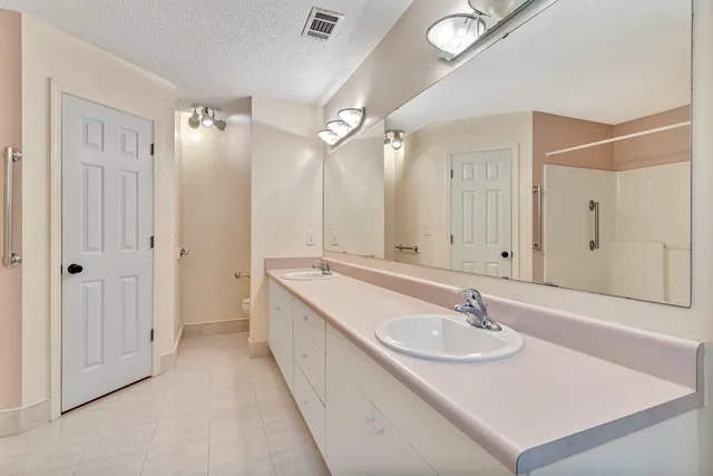 a bathroom with a sink double vanity granite tub shower and a mirror