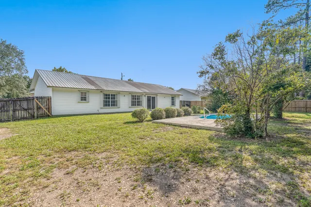 a view of a house with a backyard and a tree