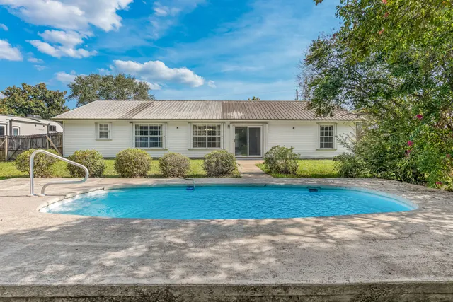 a view of a house with backyard and sitting area