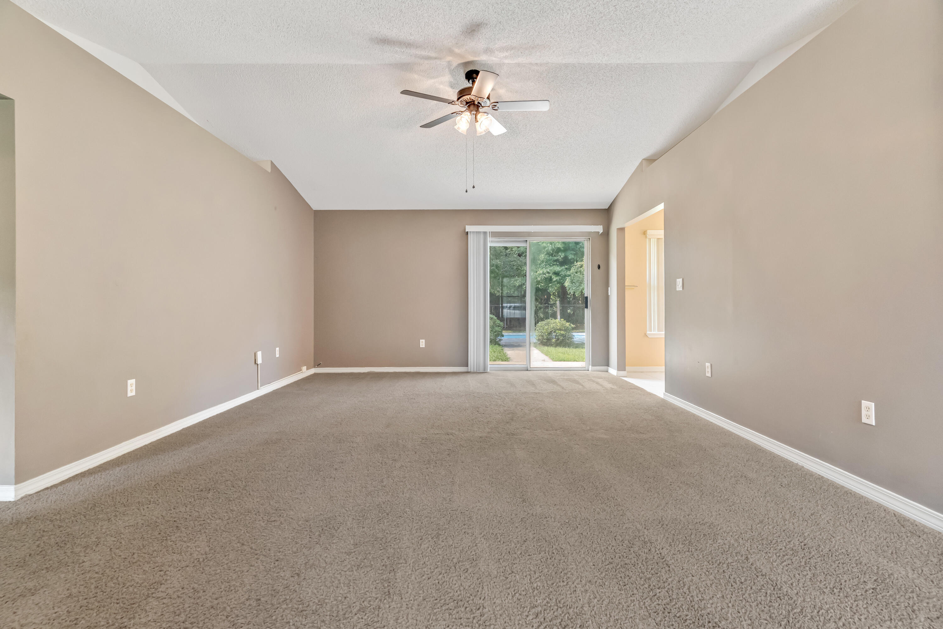 1249 Jefferyscot Drive Crestview, FL 32536 - Photo 8 of 40 an empty room with chandelier fan and window