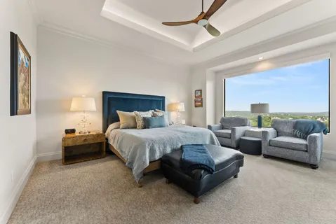 a spacious bedroom with a bed a couch and a ceiling fan