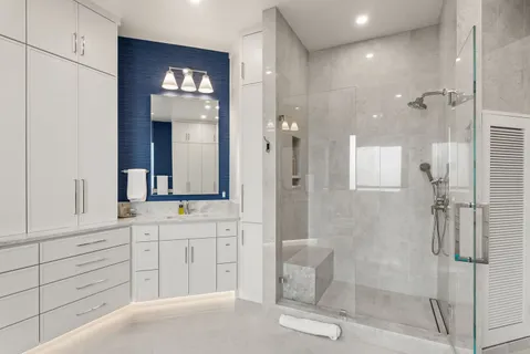 a bathroom with a double vanity sink mirror and shower