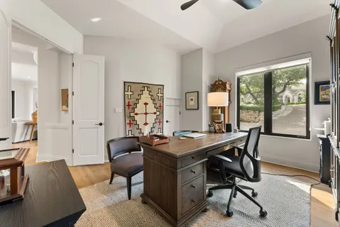 a view of a workspace with furniture and a window