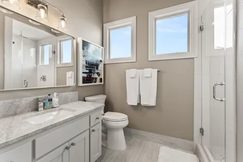 a bathroom with a granite countertop sink toilet and shower