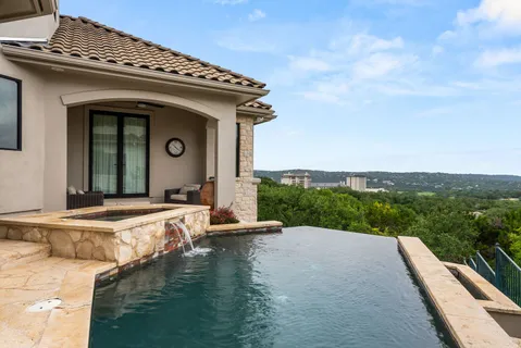 a view of a house with swimming pool and sitting area