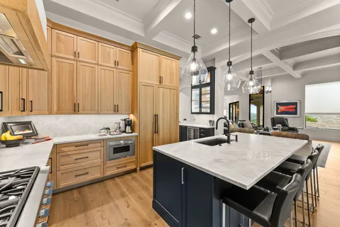 a kitchen with a stove a sink dishwasher a kitchen island with wooden cabinets and floor