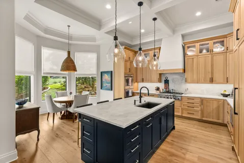 a kitchen with a stove sink and living room view