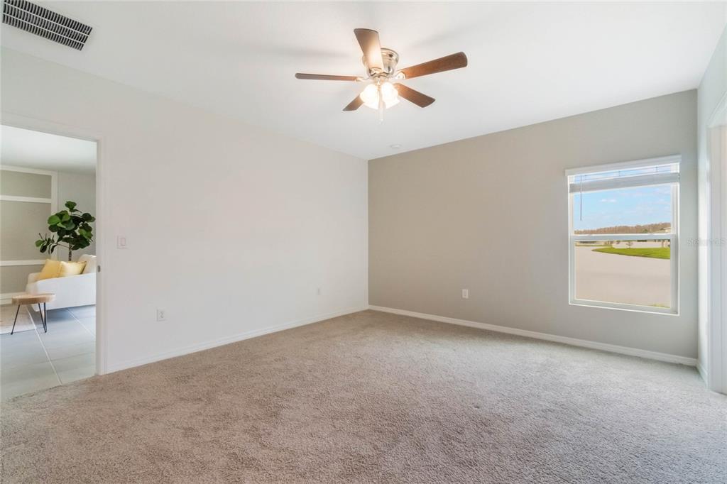 an empty room with a window and a ceiling fan