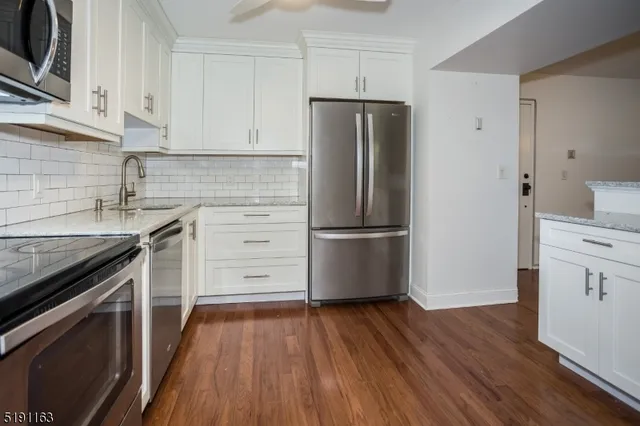 a view of a refrigerator in kitchen and wooden floor