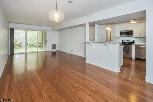 a view of a room with wooden floor and ceiling fan