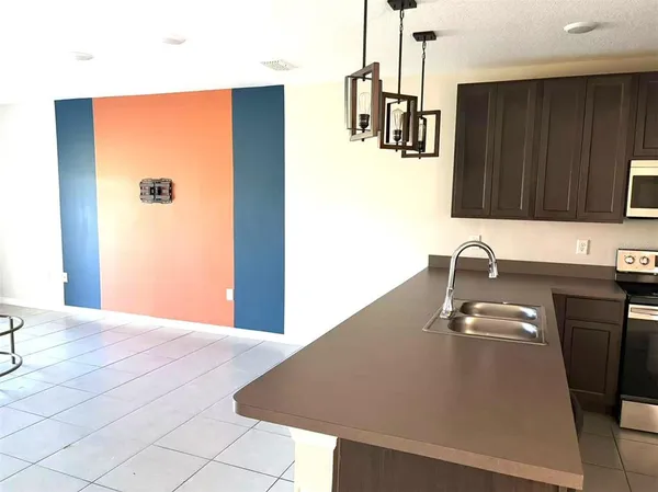 a kitchen with a refrigerator and a sink