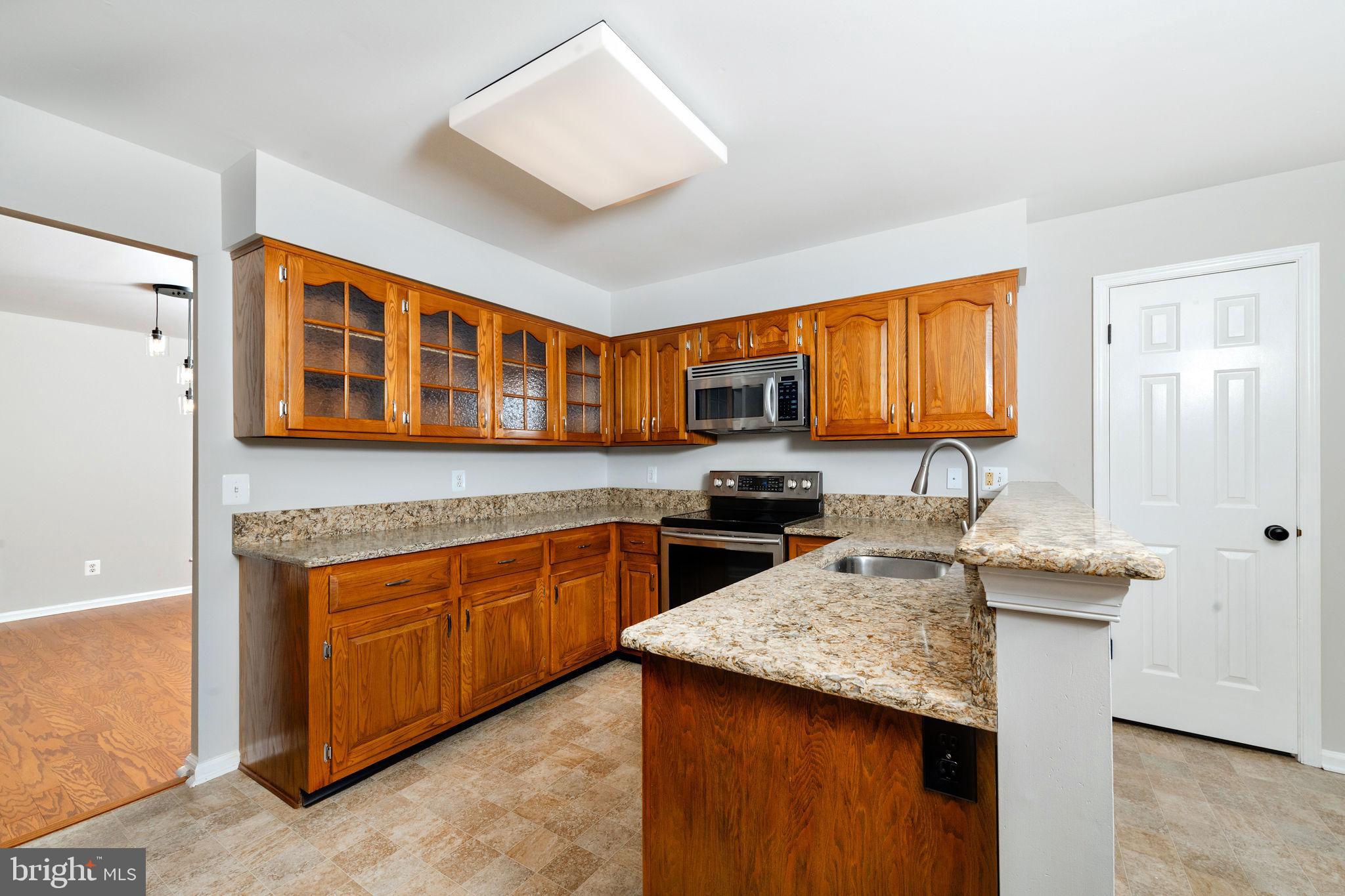 3 Patrick Henry Drive Marlton, NJ 08053 - Photo 11 of 41 a kitchen with stainless steel appliances granite countertop wooden cabinets a stove top oven a granite counter space and a window