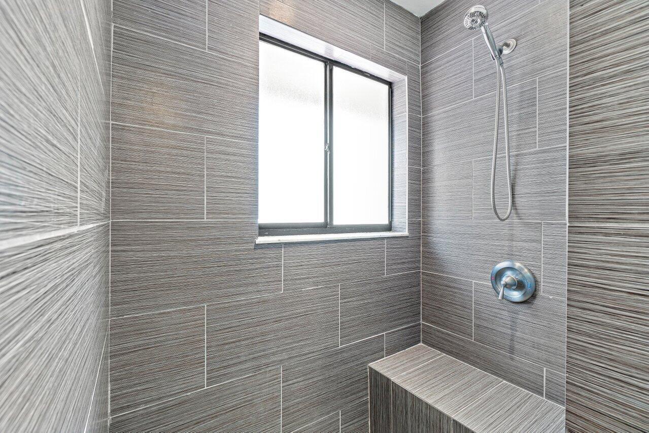 5690 Coach House Circle, Unit G Boca Raton, FL 33486 - Photo 19 of 33 BEAUTIFUL TILED STEP IN SHOWER WITH SEAT
