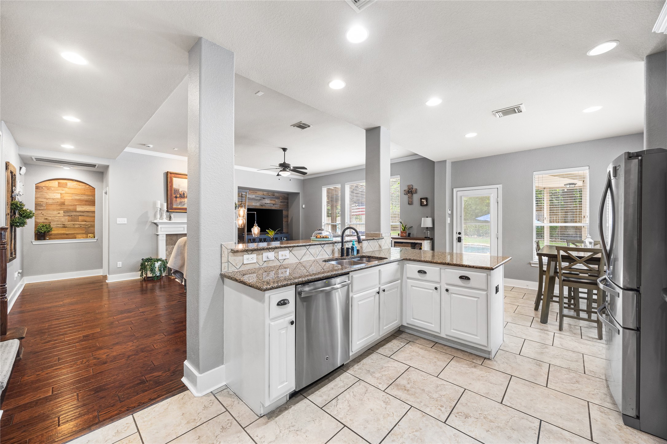 2167 Summit Mist Drive Conroe, TX 77304 - Photo 10 of 34 a kitchen with stainless steel appliances granite countertop a stove top oven a sink a dining table and chairs