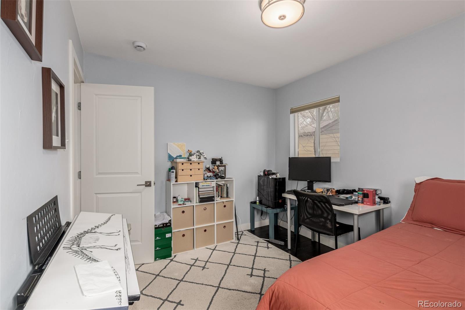 3650 Oneida Street Denver, CO 80207 - Photo 15 of 28 a bedroom with furniture and a flat screen tv