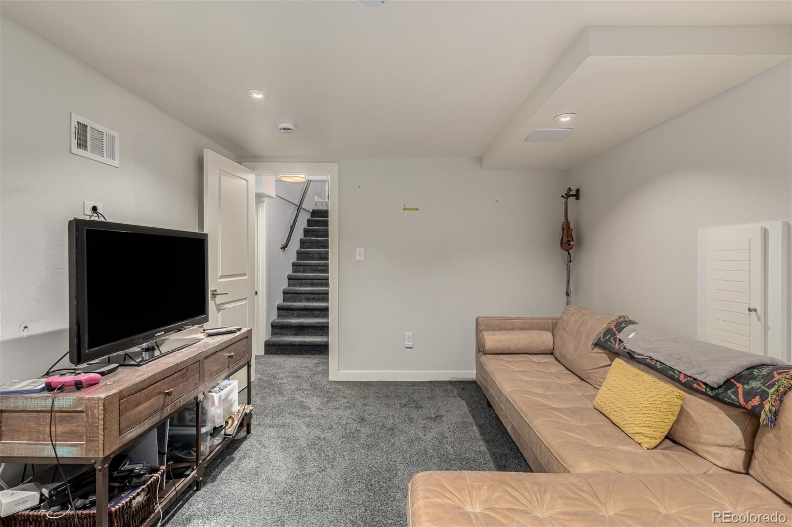 3650 Oneida Street Denver, CO 80207 - Photo 19 of 28 a living room with furniture and a flat screen tv
