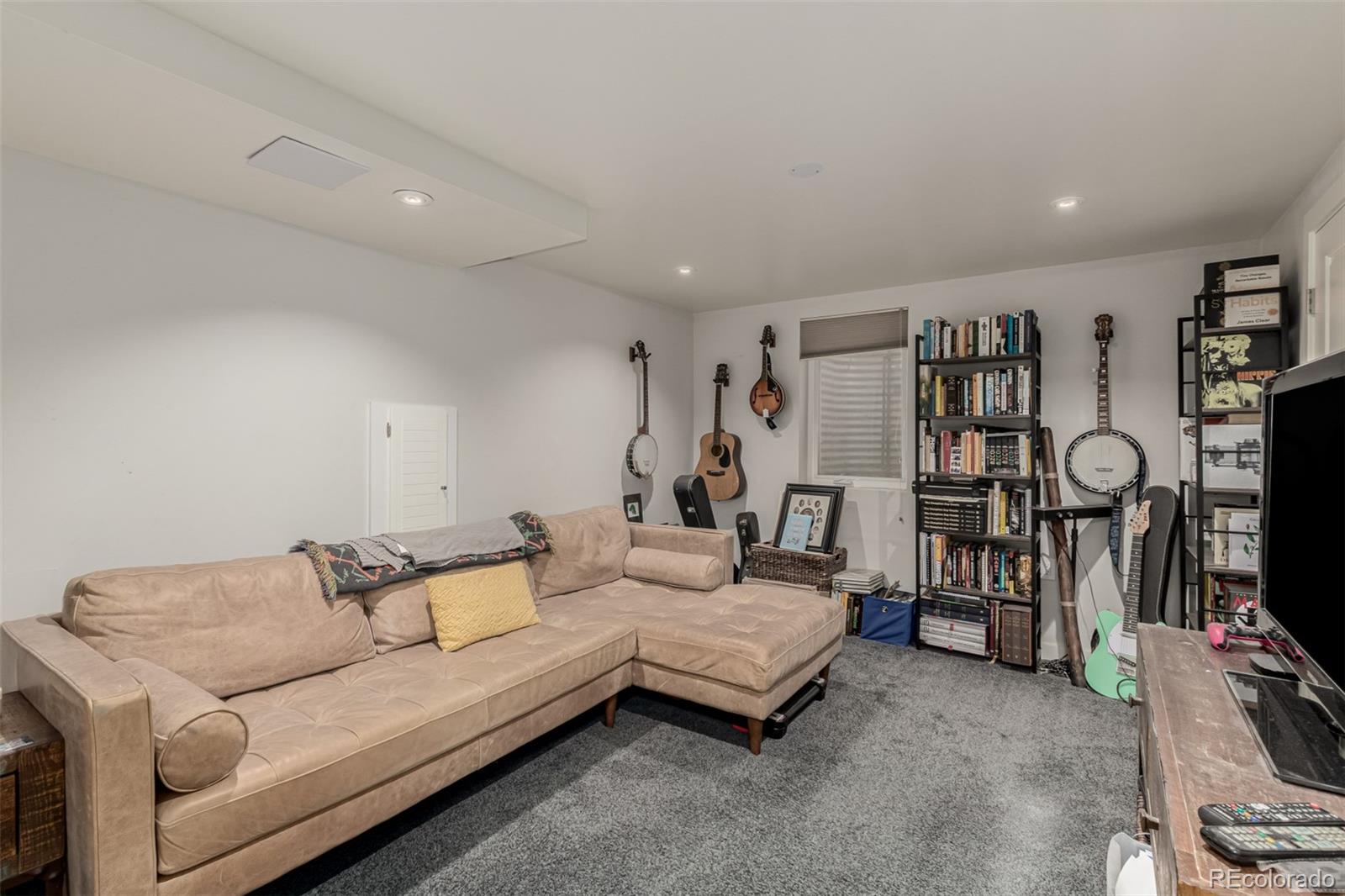 3650 Oneida Street Denver, CO 80207 - Photo 20 of 28 a living room with furniture and a flat screen tv