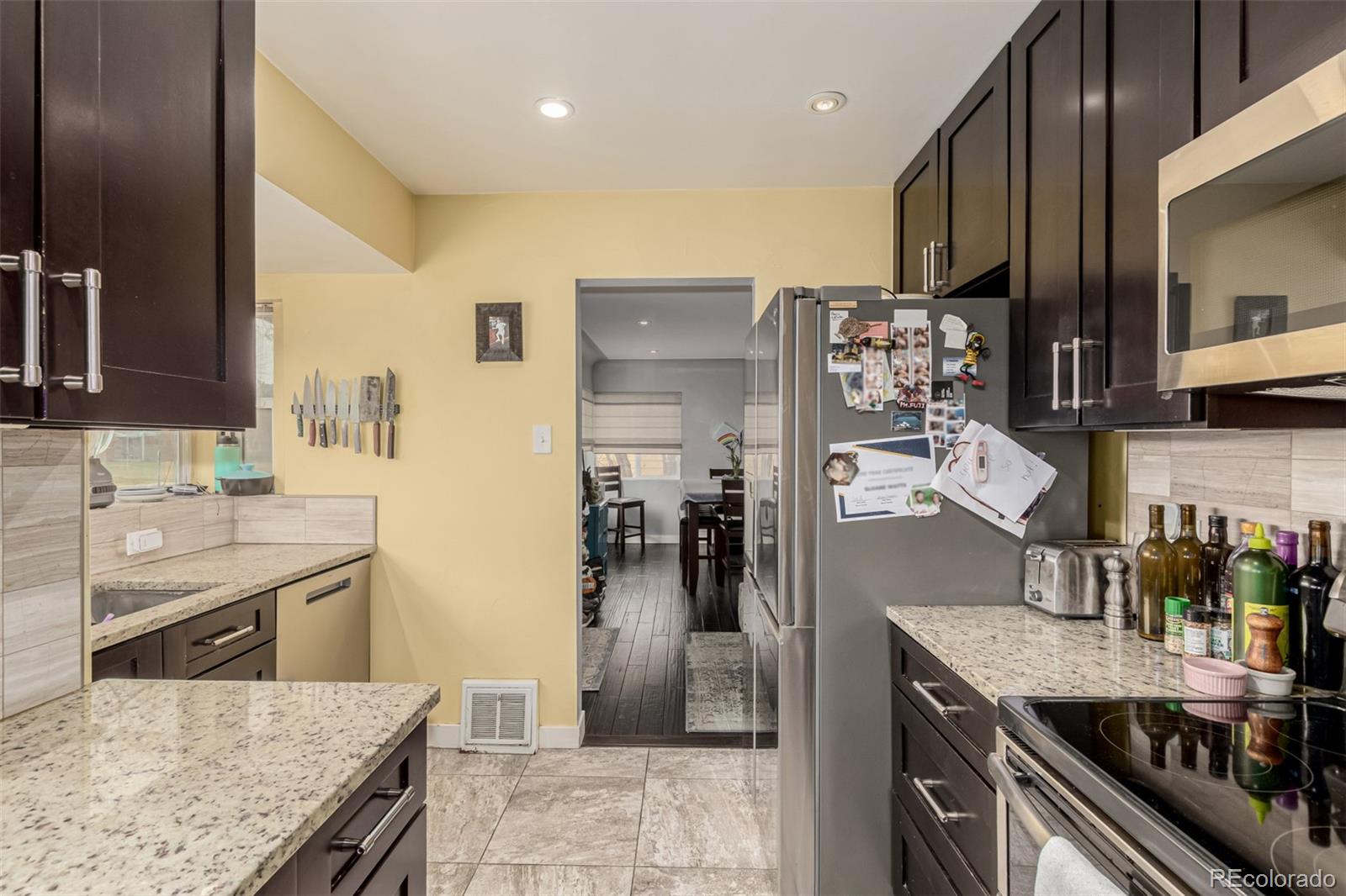 3650 Oneida Street Denver, CO 80207 - Photo 7 of 31 a kitchen with stainless steel appliances granite countertop a sink stove and refrigerator