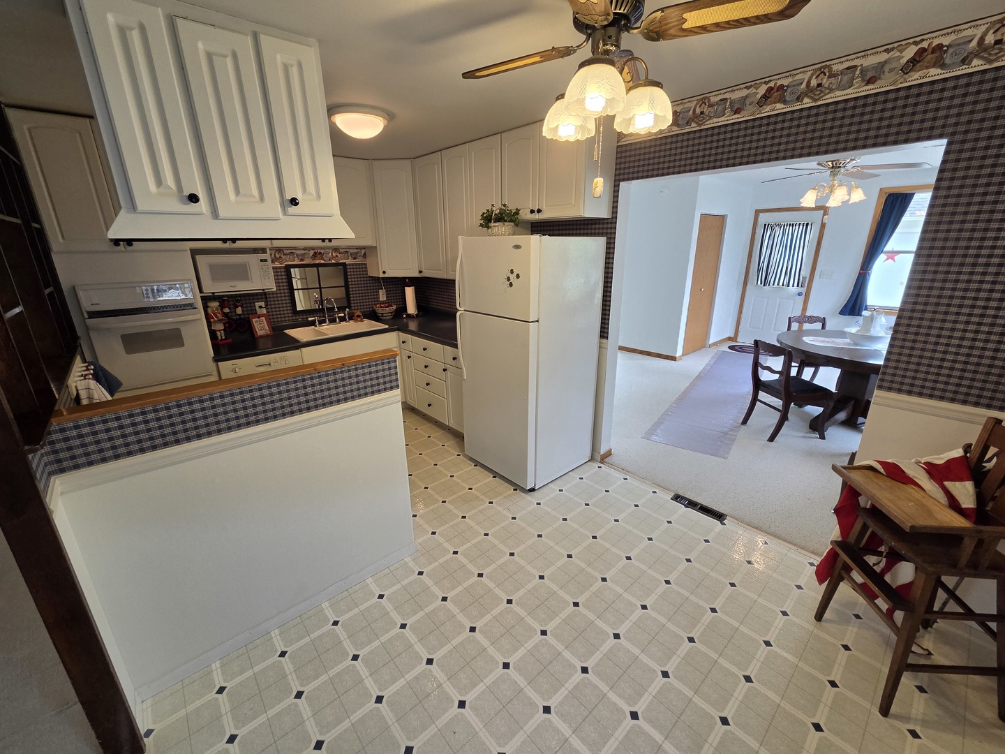 1105 6th Street West Milan, IL 61264 - Photo 8 of 23 a kitchen with granite countertop a refrigerator a stove a sink dishwasher and white cabinets with wooden floor