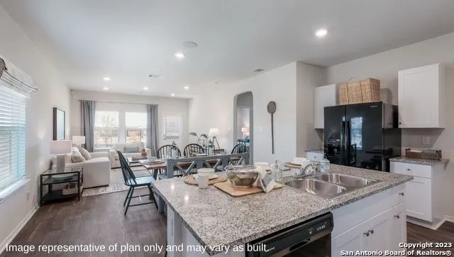 a kitchen with granite countertop a sink and cabinets