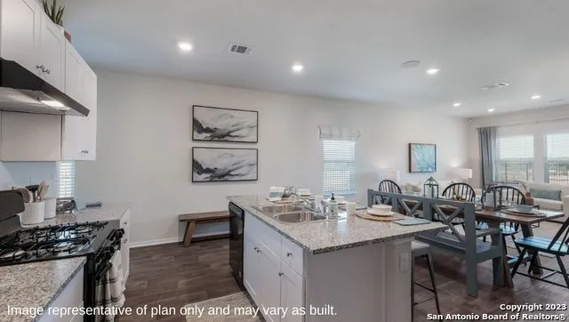 a kitchen with a sink and a stove top oven