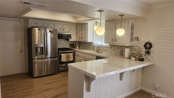 a kitchen with stainless steel appliances a sink stove and refrigerator