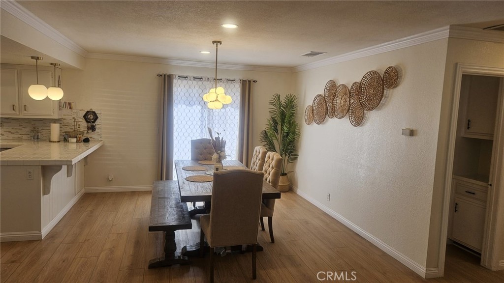 10671 Pinon Avenue Hesperia, CA 92345 - Photo 10 of 13 a view of a dining room with furniture and a wooden floor
