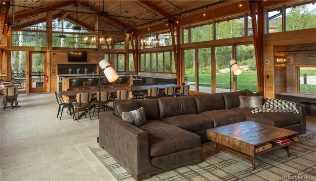 a living room with stainless steel appliances furniture and a large window