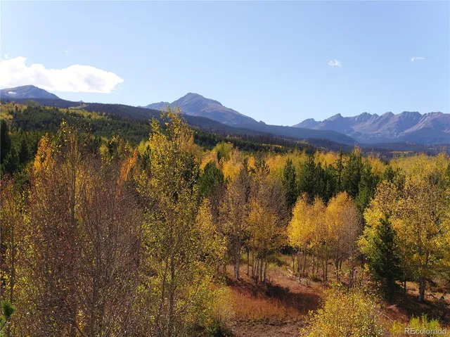 a view of mountain with wooden floor and mountains in the background