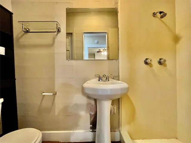 a bathroom with a sink a toilet and shower