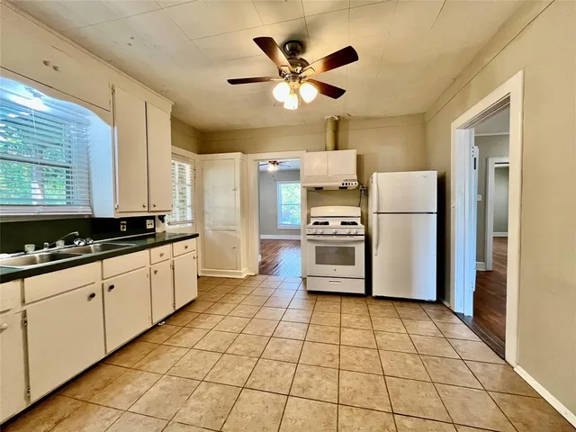 a kitchen with a refrigerator a sink and a stove top oven