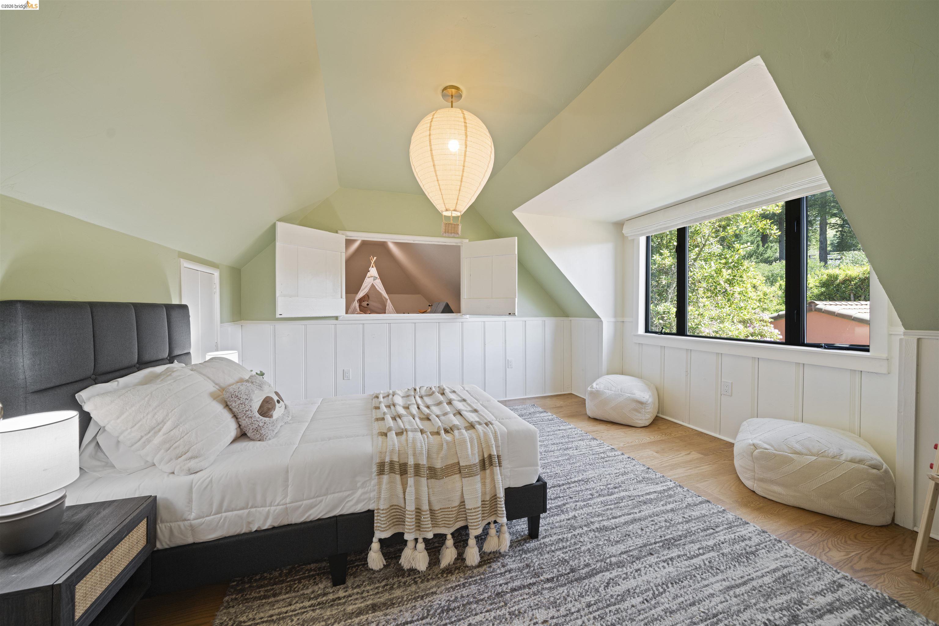 1170 Sterling Avenue Berkeley, CA 94708 - Photo 32 of 52 Bedroom featuring wood finished floors, lofted ceiling, and a decorative wall