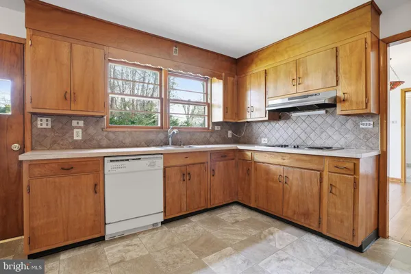 a kitchen with granite countertop a sink cabinets and window