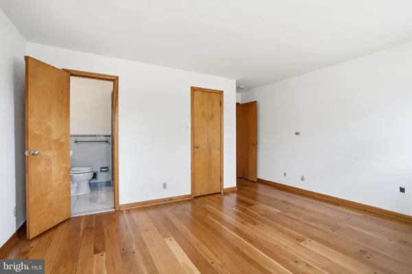 an empty room with wooden floor and a window