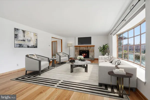 a living room with furniture a fireplace and a large window